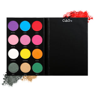 Black eyeshadow palette with 12 shades of circular compressed eyeshadows. From left to right, First row: purple, blue, red. Second Row: pink, bubblegum pink. Third row: white, yellow, orange. Last row: dark green, peach, bright green