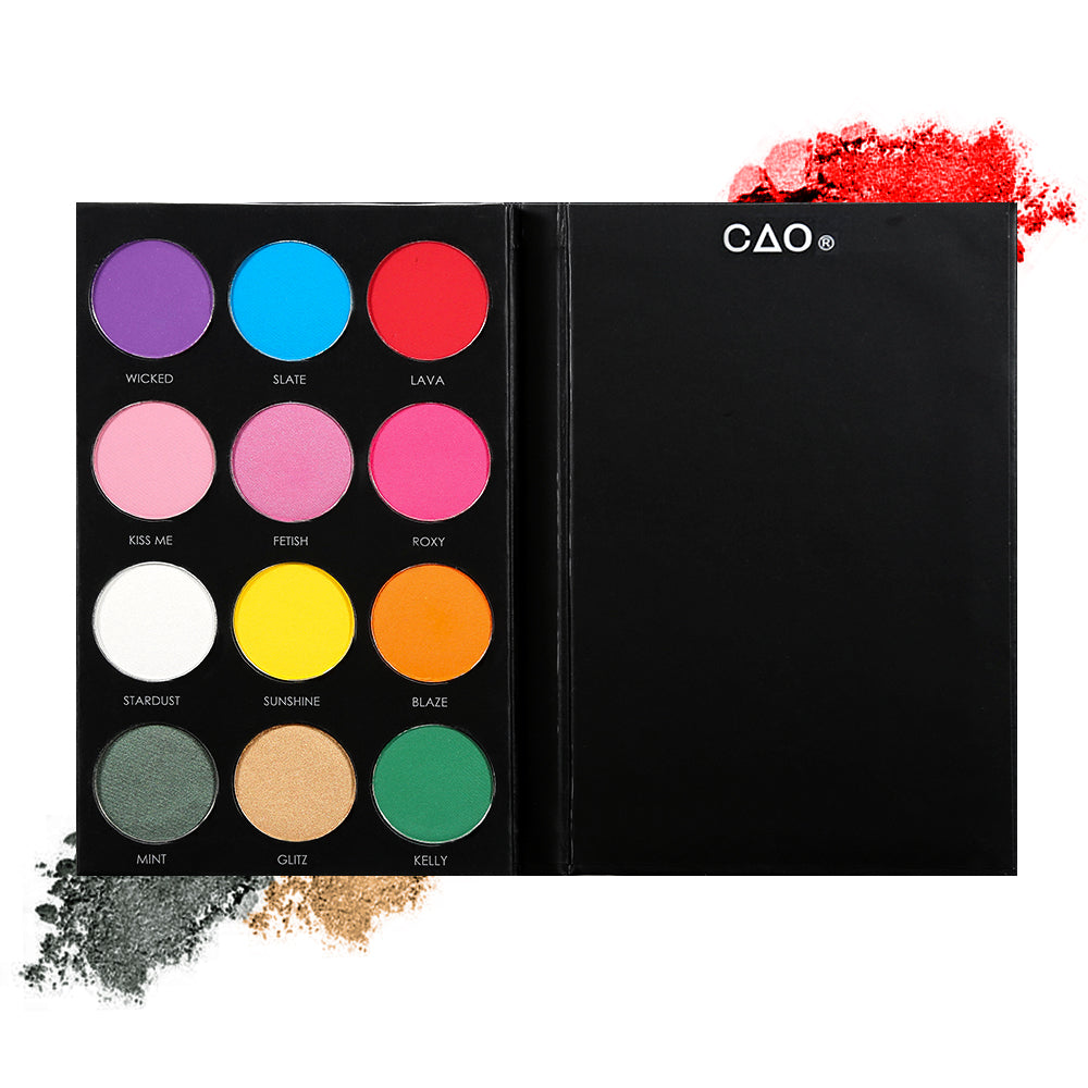 Black eyeshadow palette with 12 shades of circular compressed eyeshadows. From left to right, First row: purple, blue, red. Second Row: pink, bubblegum pink. Third row: white, yellow, orange. Last row: dark green, peach, bright green 