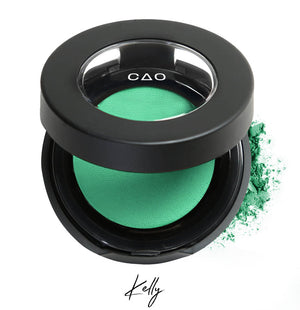 Semi- open eyeshadow compact with light neon green eyeshadow in shade "Kelly" compressed powder and on white background with loose eyeshadow powder on white..
