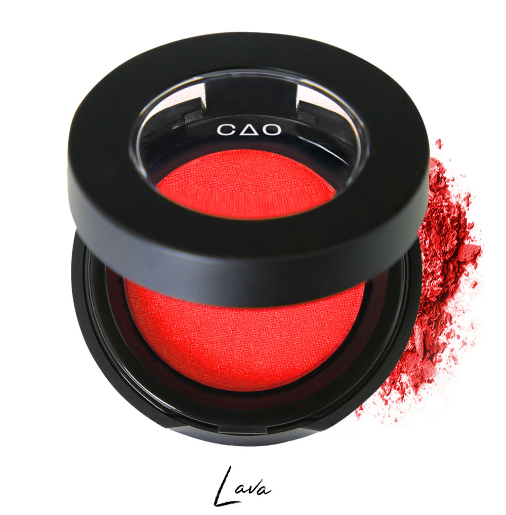 Semi- open eyeshadow compact with bright red eyeshadow in shade "lava" compressed powder and on white background with loose eyeshadow powder on white..