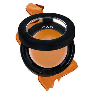 Round Matte Black Component, clear round top window, filled with round creamy concealer shade in "Dark" on top of creamy swatch.