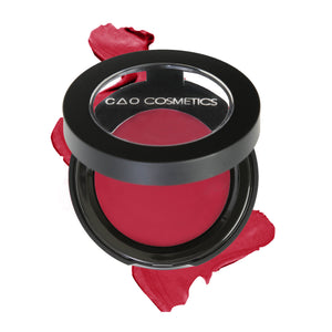 Round Matte Black Component, clear round top window, filled with round creamy dual lip and cheek product shade in "Desire" on top of creamy swatch.